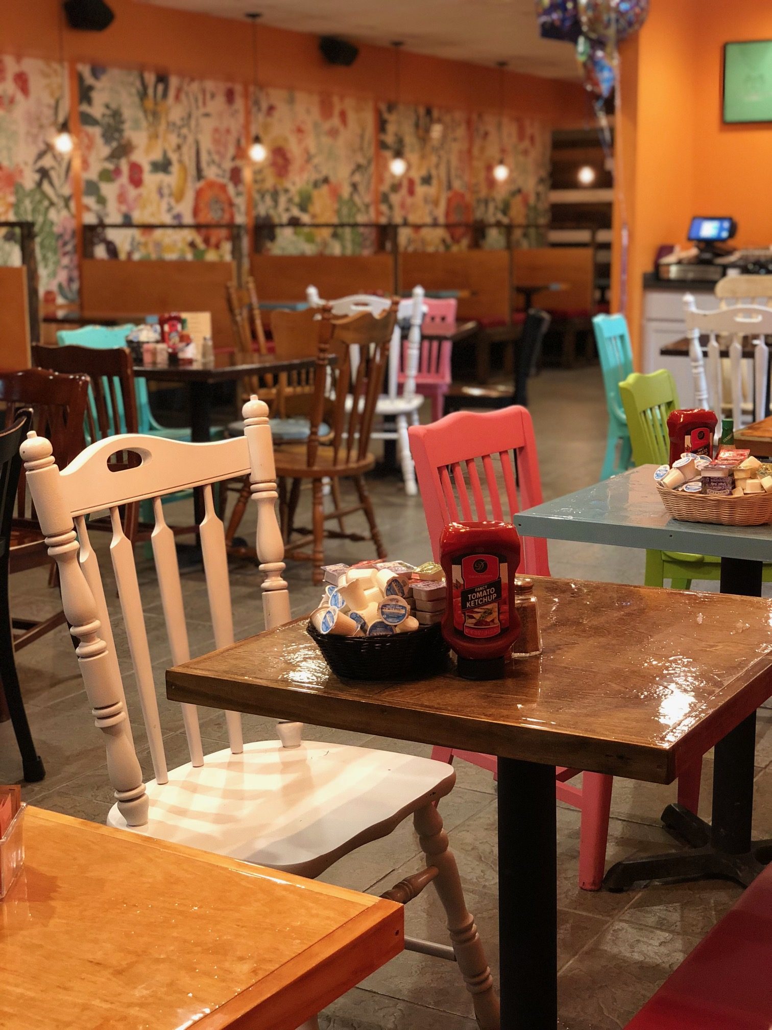 Another view of the dining room with painted chairs and red booth seating