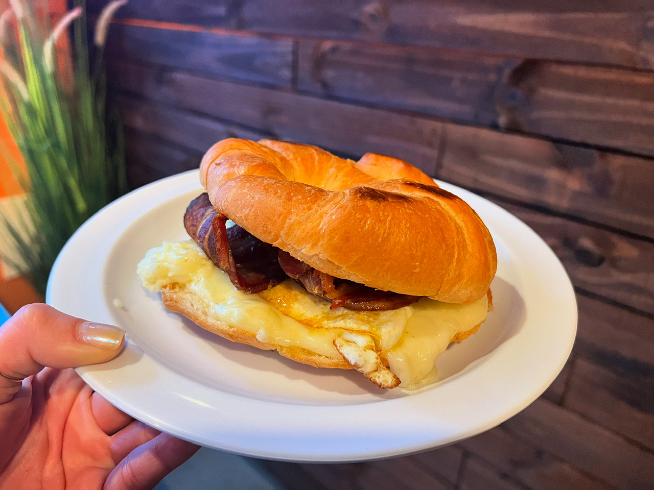 Egg, cheese and bacon breakfast sandwich on a toasted croissant