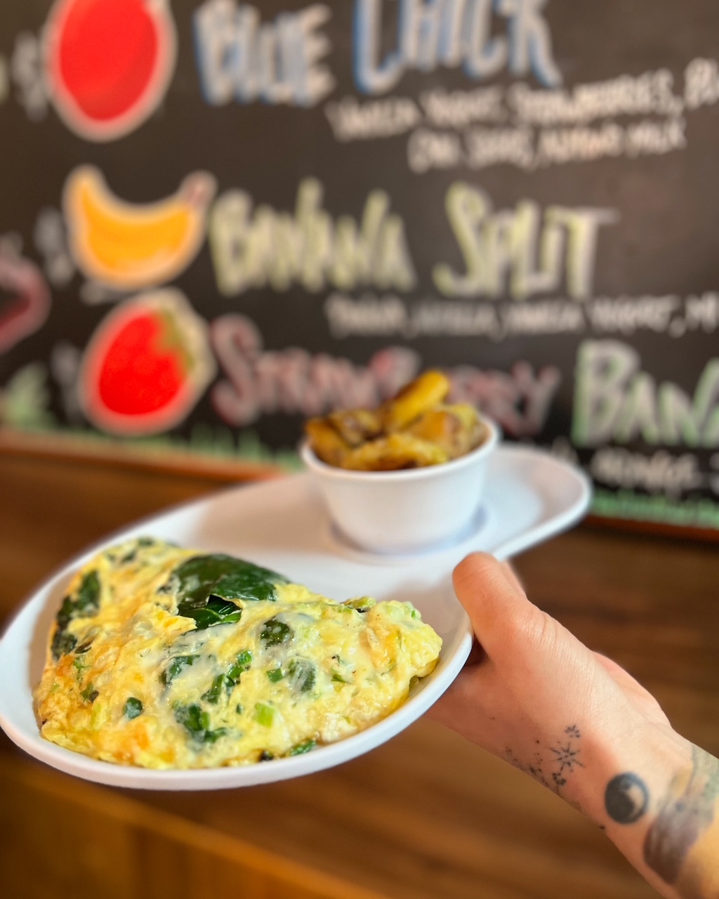 Jalapeno omelet with hash browns in front of the smoothie menu board