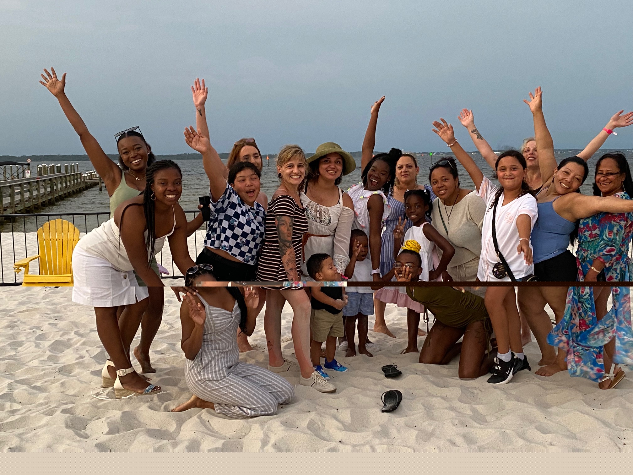 The whole team and their families posing together on the beach